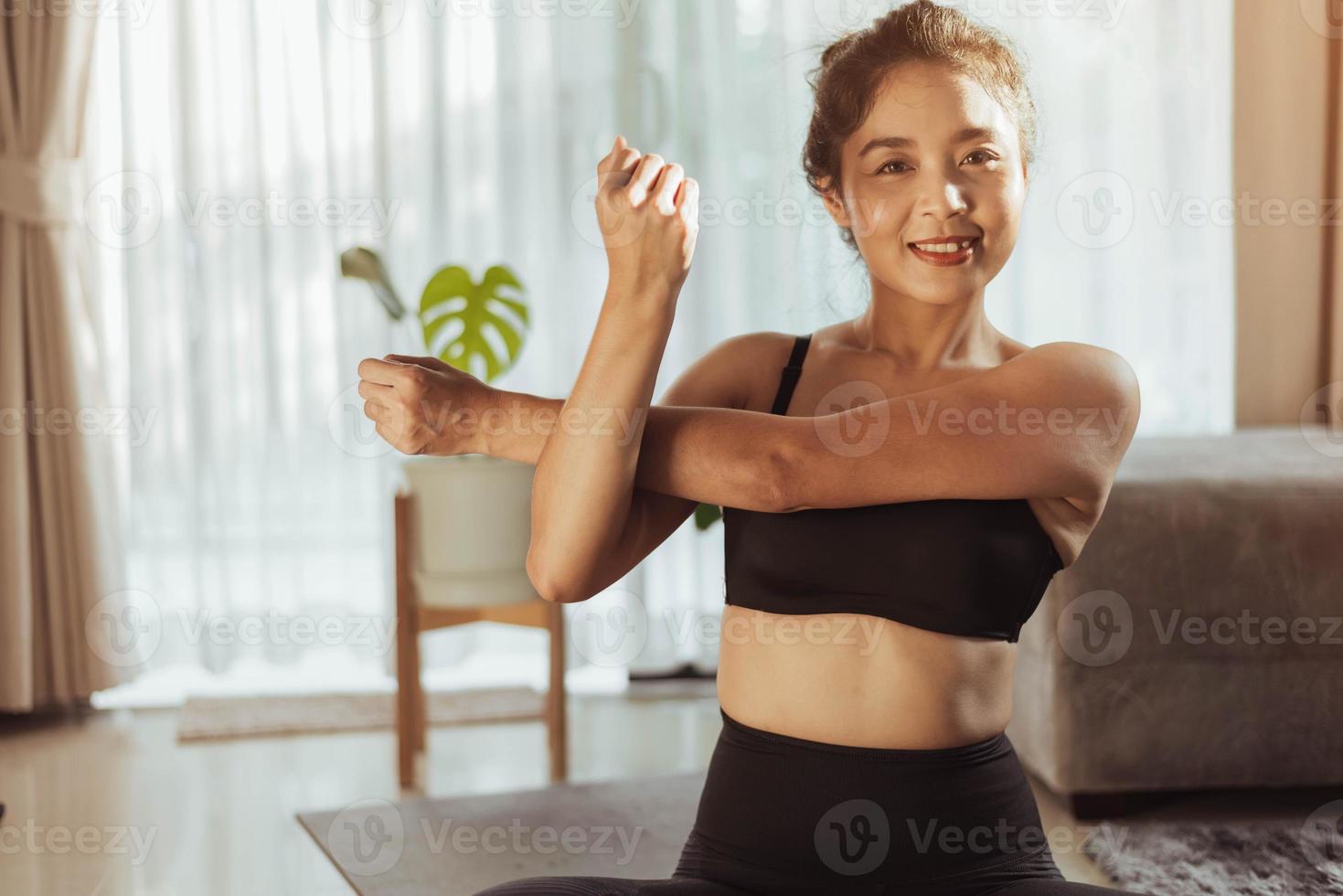 Young woman doing yoga stretching yoga online at home. Woman practicing home yoga. photo