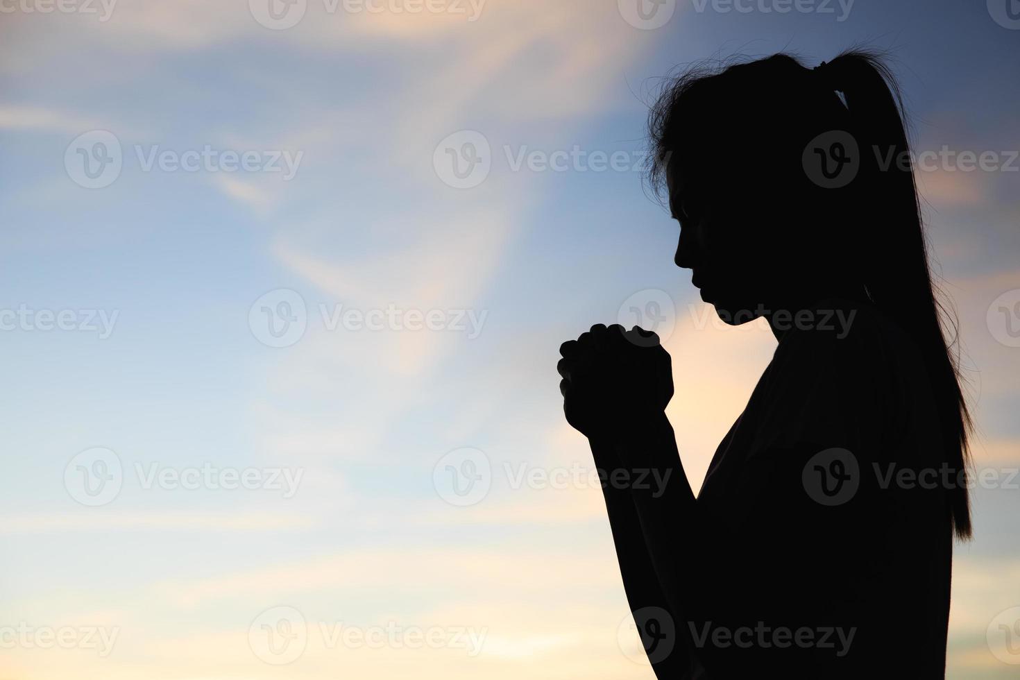 la silueta de la niña oró en las montañas para pensar en un dios amoroso, alabamos a dios. foto