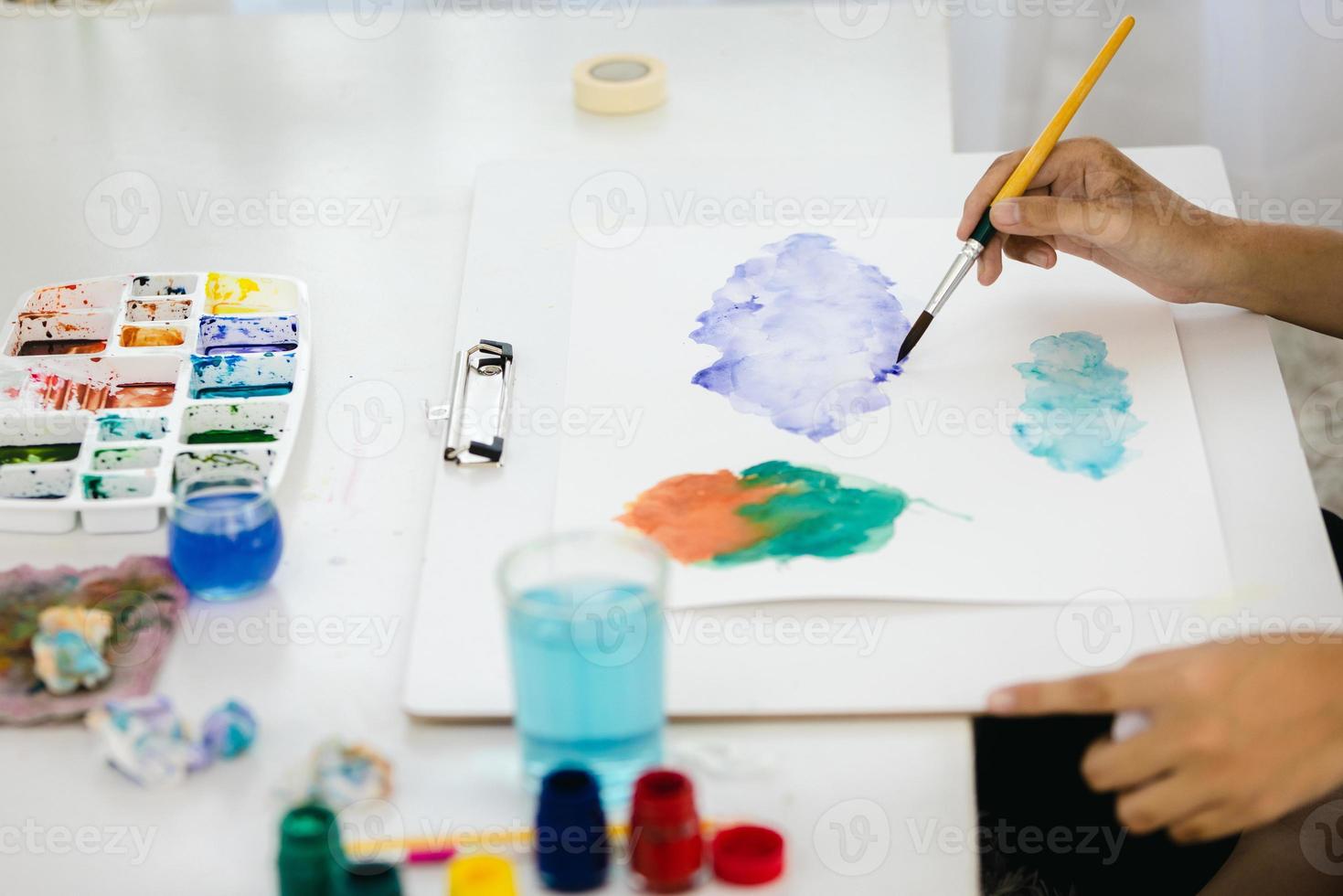 Close-up  Paint on a drawing board in the house to create art with watercolors and brushes. photo