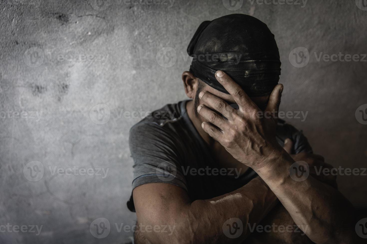 Men who show stress and loneliness, Homeless man drug  addict sitting alone and depressed  at an abandoned house feeling anxious and lonely, social documentary concept, Copy space photo