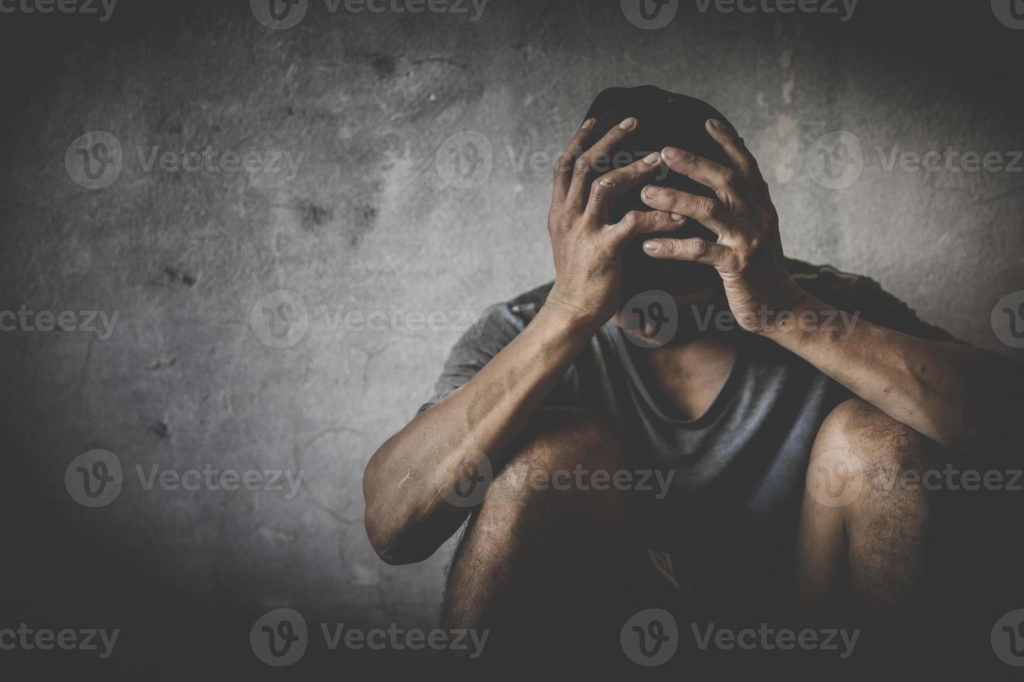 Men who show stress and loneliness, Homeless man drug  addict sitting alone and depressed  at an abandoned house feeling anxious and lonely, social documentary concept, Copy space photo