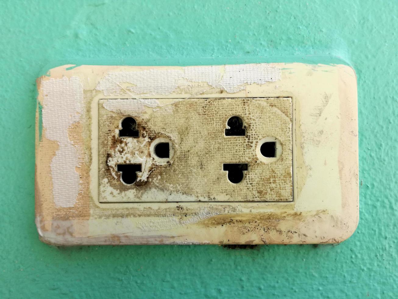 The old plastic power socket on the wall is dangerous. photo