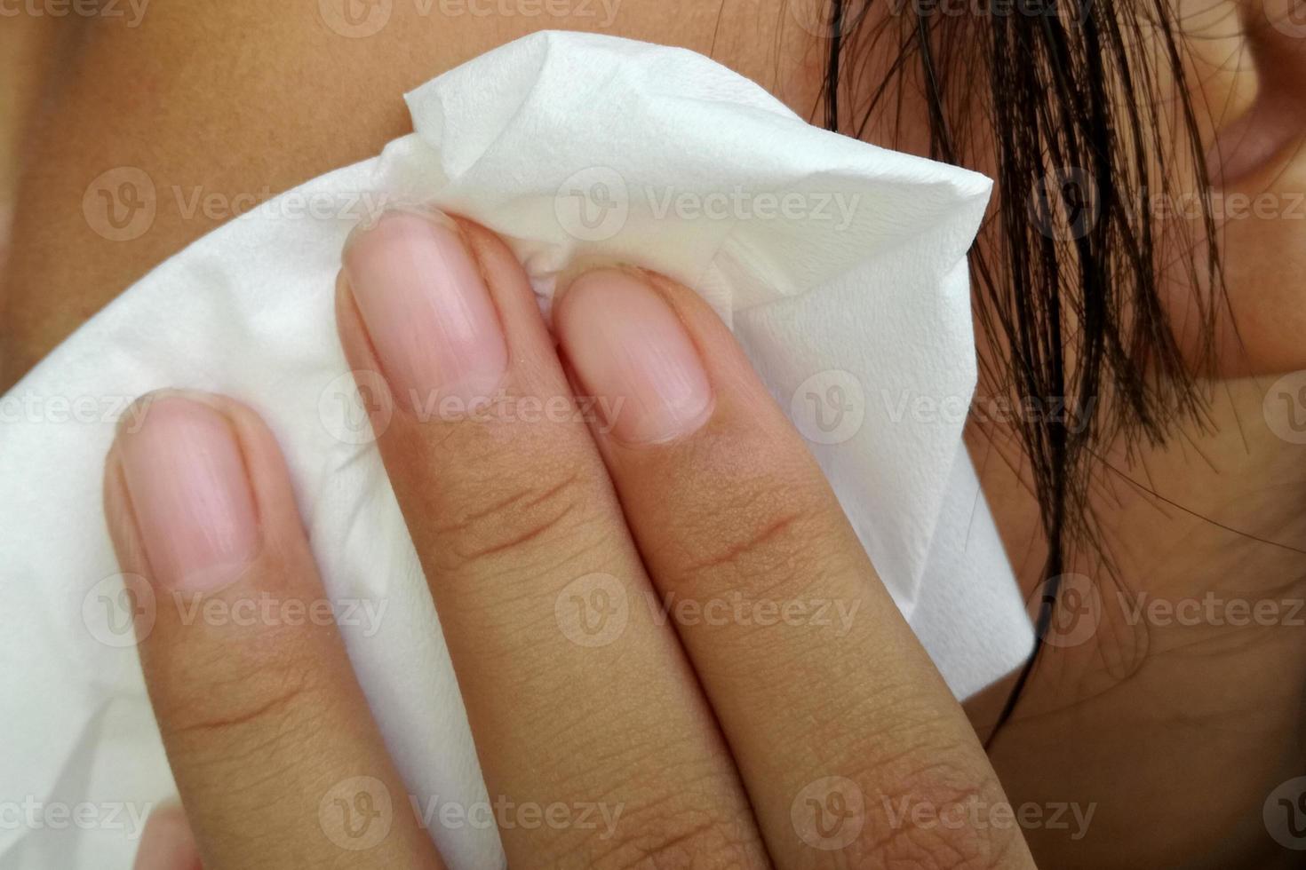 mano sosteniendo un pañuelo para limpiar la cara. foto