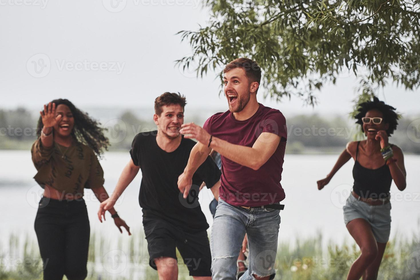 Catch me if you can. People have party outside. Multi ethnic friends have meeting at weekend time photo