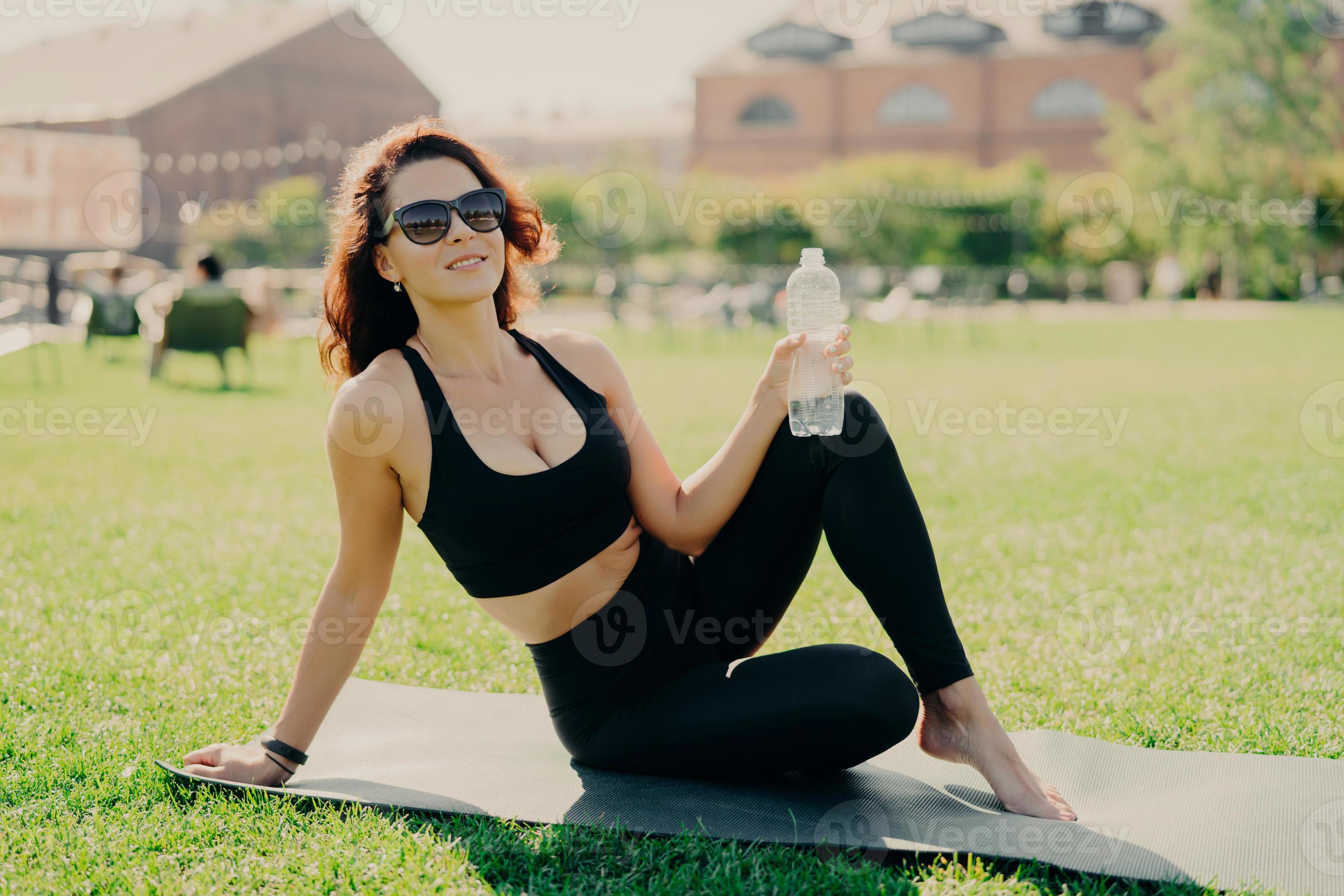 Positive active woman has perfect body shape as result of regular fitness training poses on