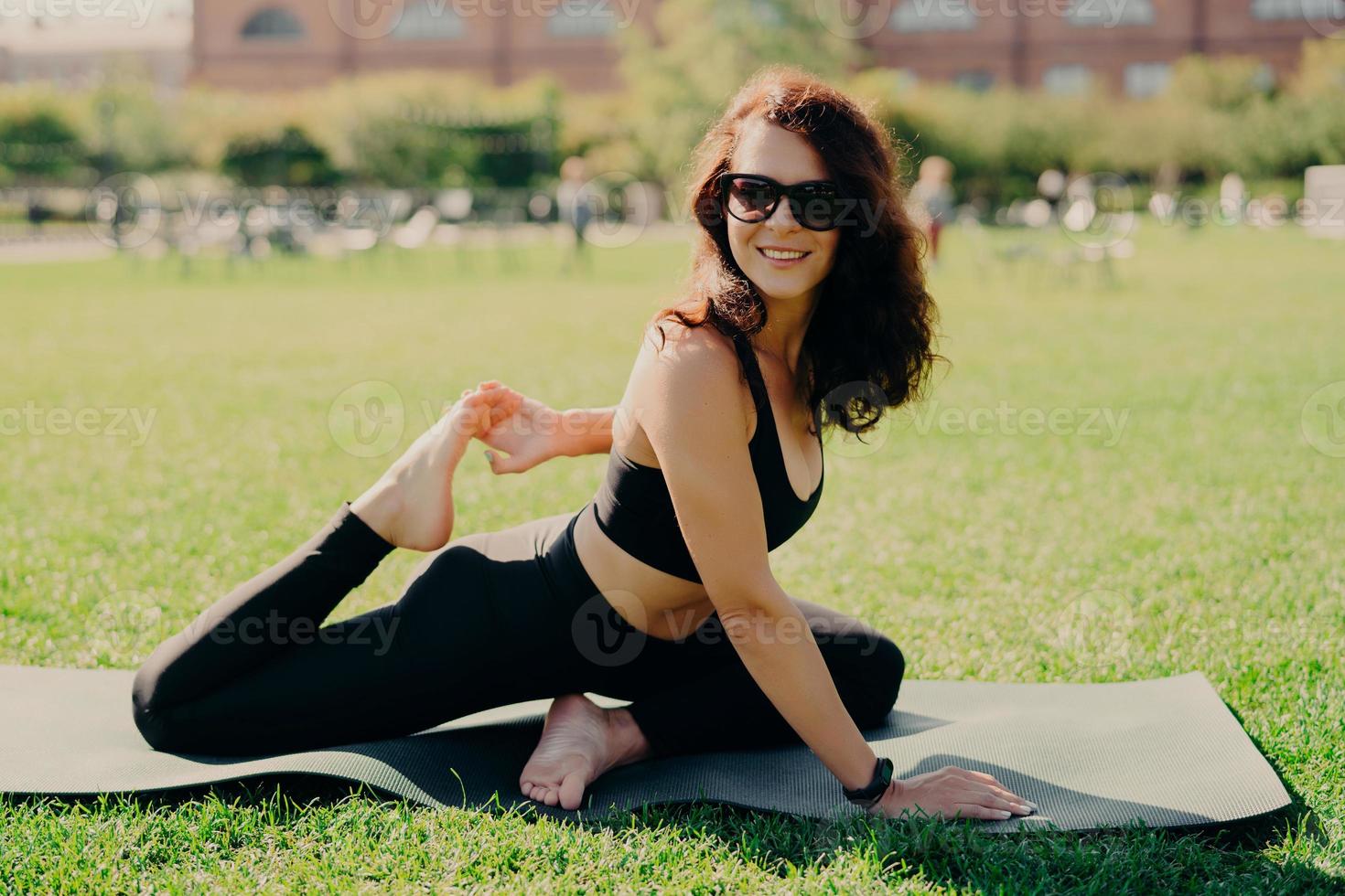 Smiling positive brunette woman lying at karemat on fitness mat