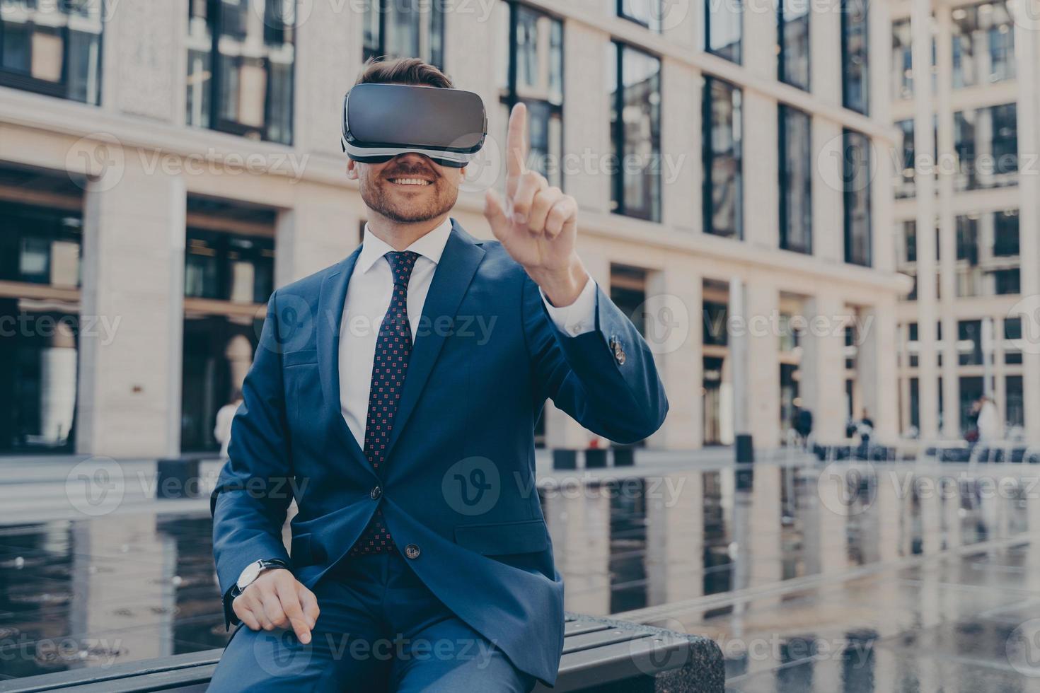 joven hombre negocios con traje azul que gafas de realidad virtual mientras sienta al aire libre 8637419 Foto de stock en