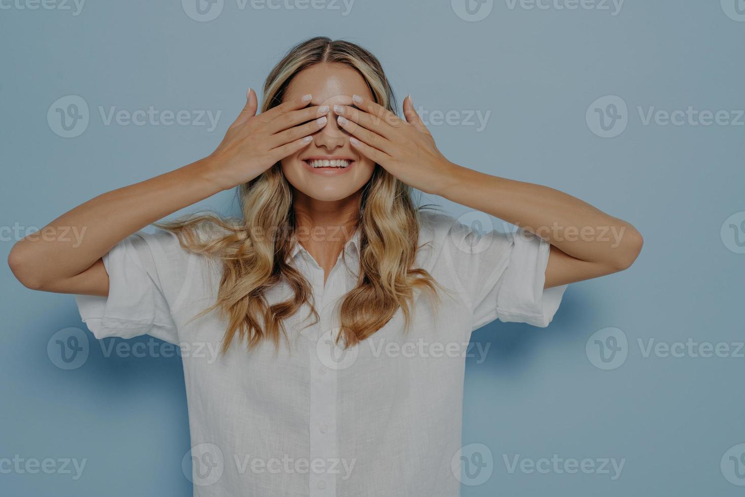 Blonde girl covering her eyes with hands photo
