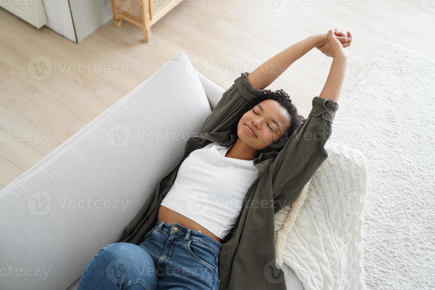 Young happy woman is falling asleep and smiling. Lazy weekend morning at cosy home. photo