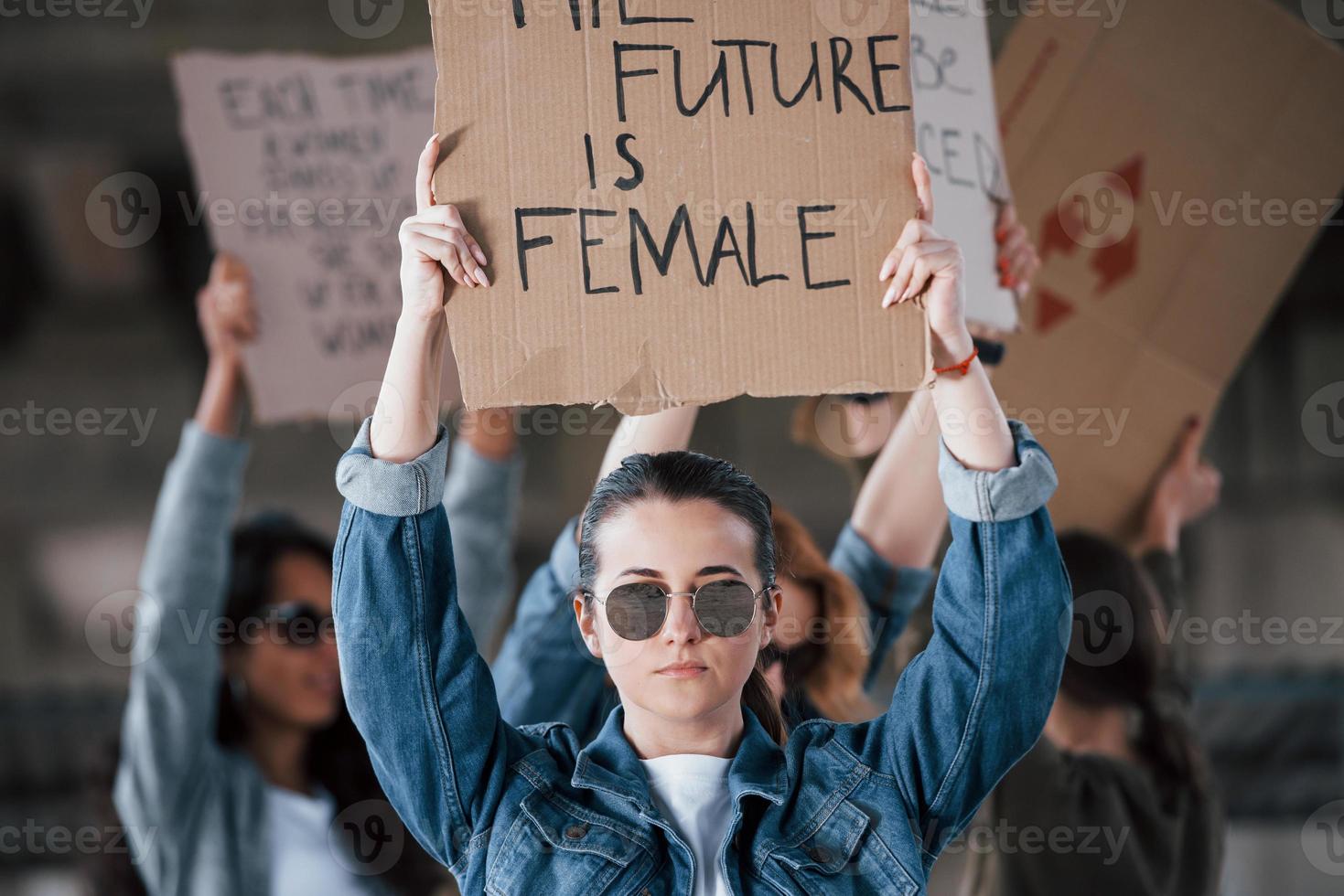 reflejo del suelo en gafas de sol. grupo de mujeres feministas tienen protesta por sus derechos al aire libre foto