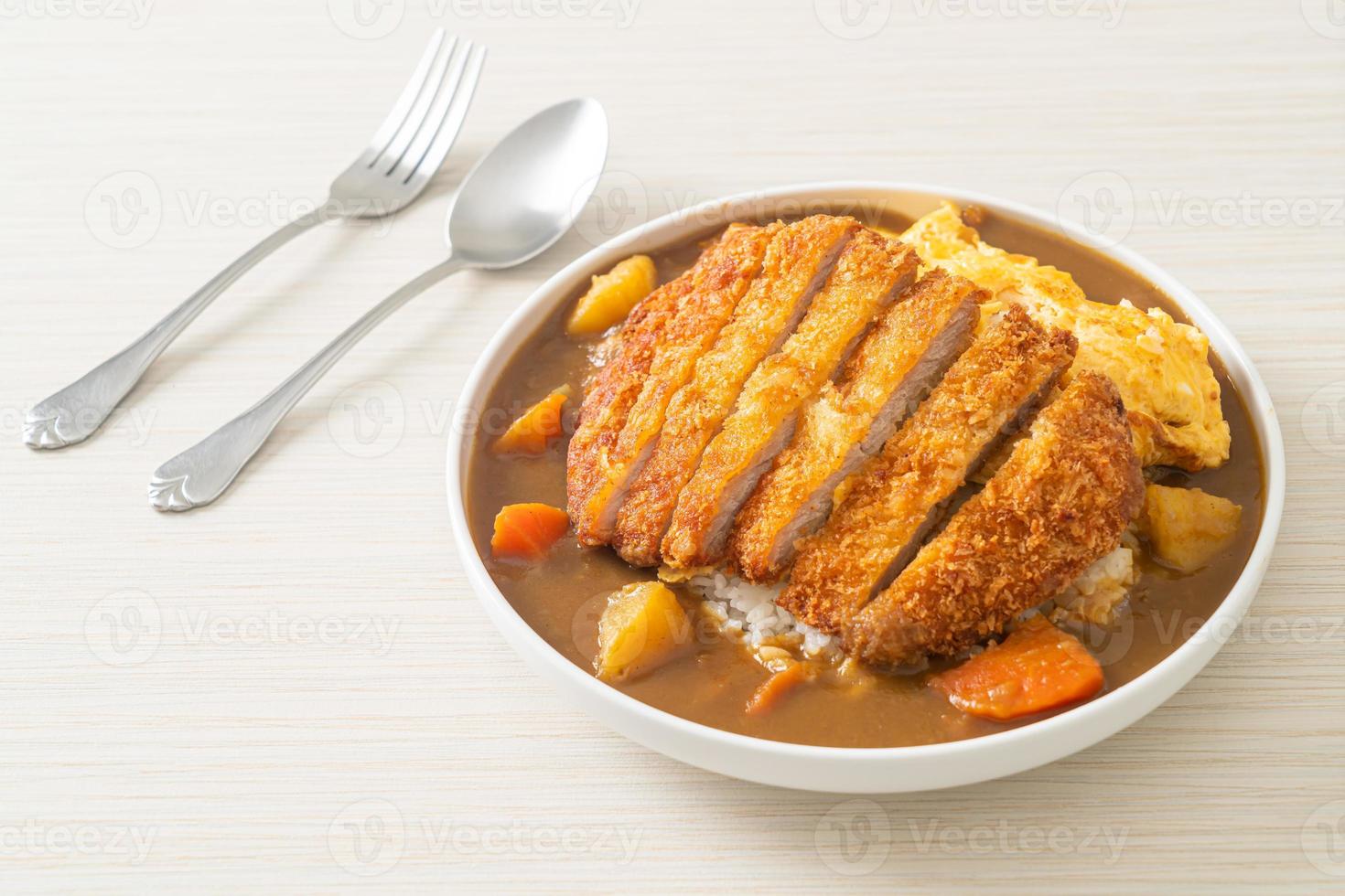 arroz al curry con chuleta de cerdo frita y tortilla cremosa foto