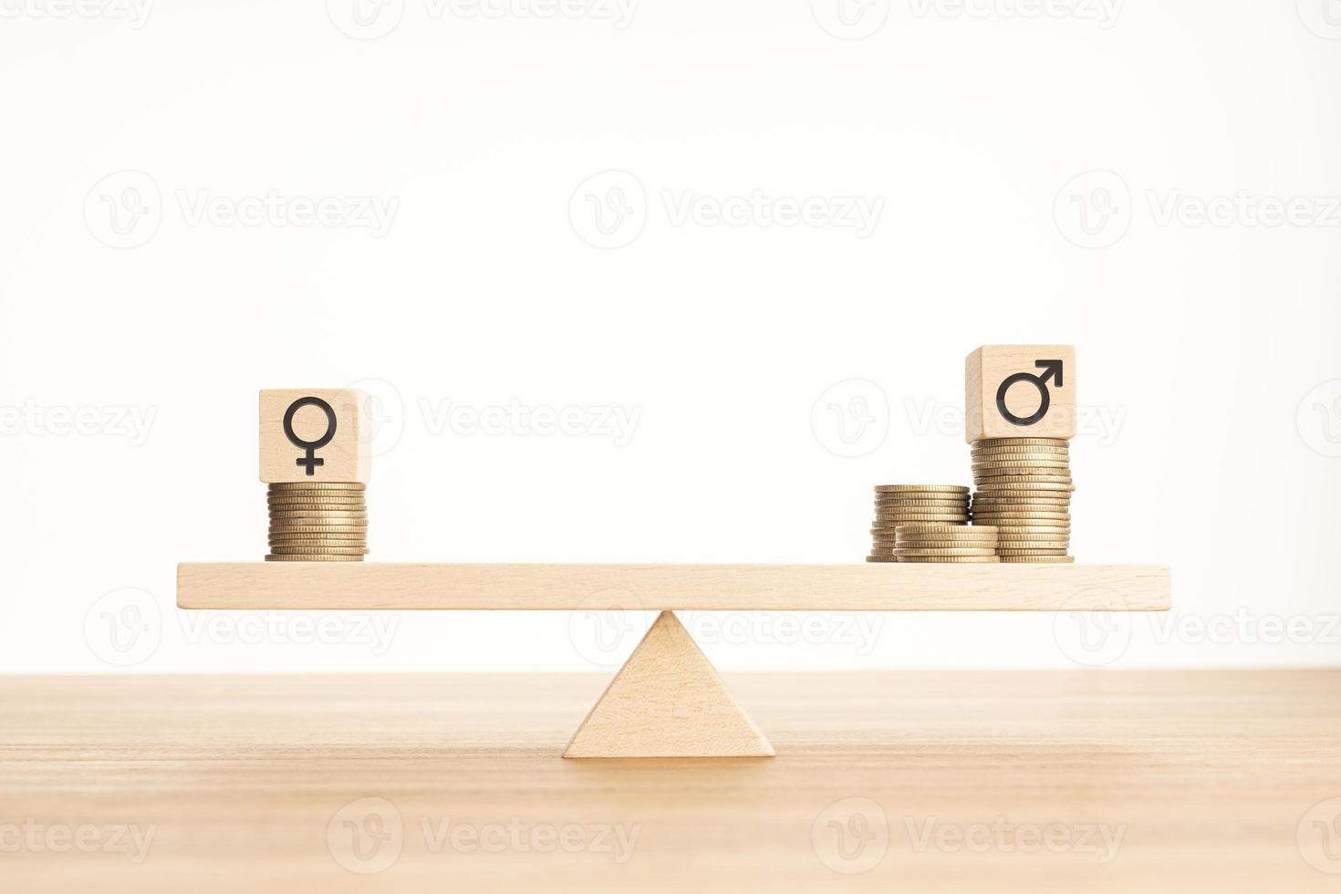 Wage gap between men and women concept. Wooden block with gender symbol on stacked coins on a seesaw. Copy space photo
