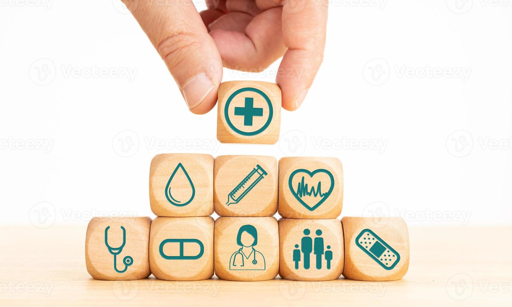 Health insurance concept. Wooden blocks with medical icons and Hand holding a wooden block with healthcare medical icon photo