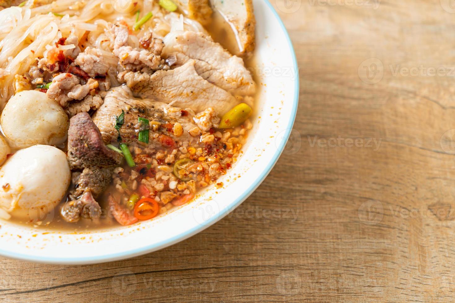 noodles with pork and meatballs in spicy soup photo