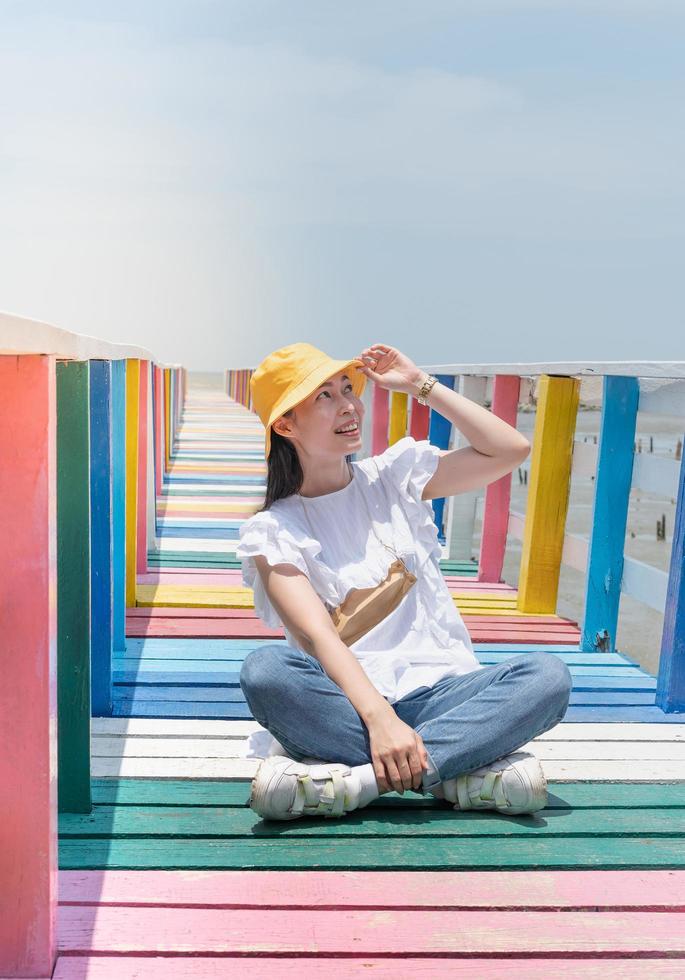 The back view of asian woman standing and taking photo on the rainbow bridge to see the viewpoint at the Samut Sakorn province.
