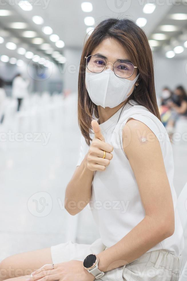 Happy woman showing thumb after receiving vaccine. Vaccination, immunization, inoculation and Coronavirus pandemic photo