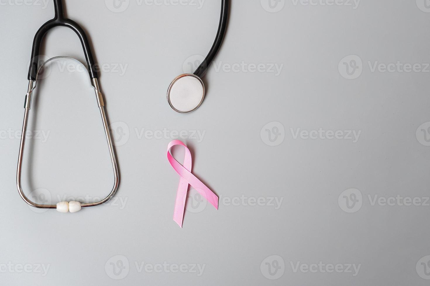 Breast Cancer Awareness, Pink Ribbon with Stethoscope on grey background for supporting people living and illness. Woman Healthcare and World cancer day concept photo