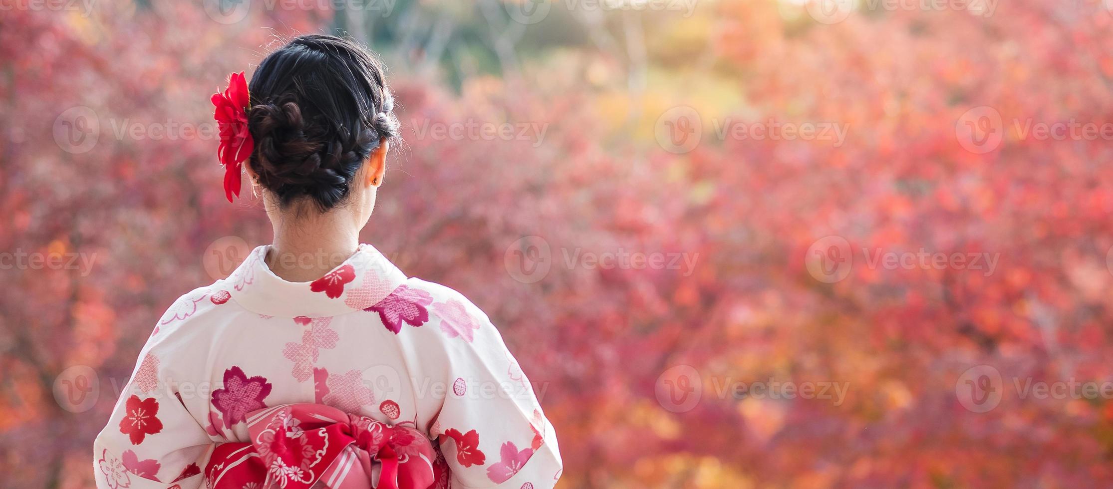 joven turista vistiendo kimono disfrutando con hojas coloridas en el templo kiyomizu dera, kyoto, japón. chica asiática con estilo de cabello en ropa tradicional japonesa en la temporada de follaje de otoño foto