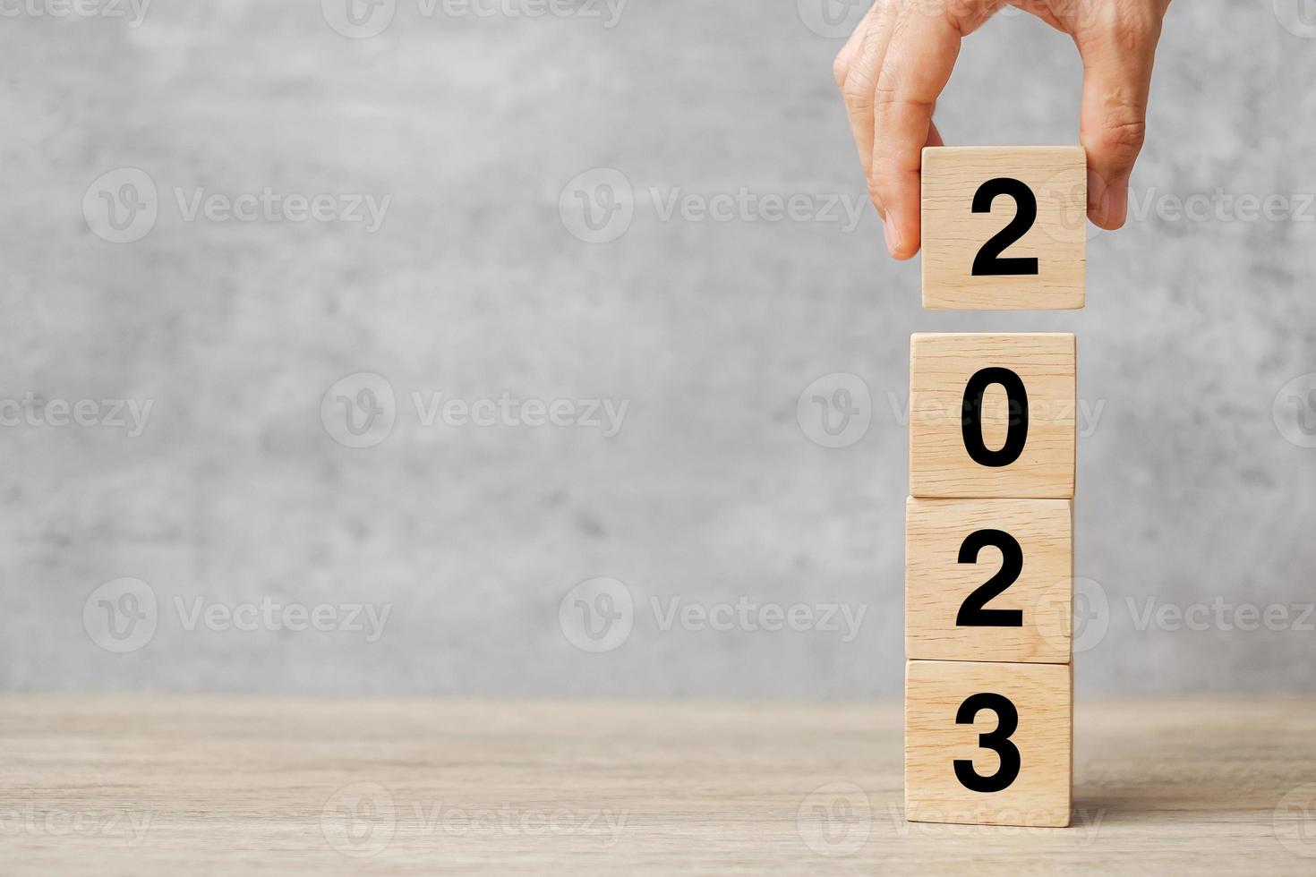 hand holding block 2023 text on table. Resolution, strategy, plan, goal, motivation, reboot, business and New Year holiday concepts photo