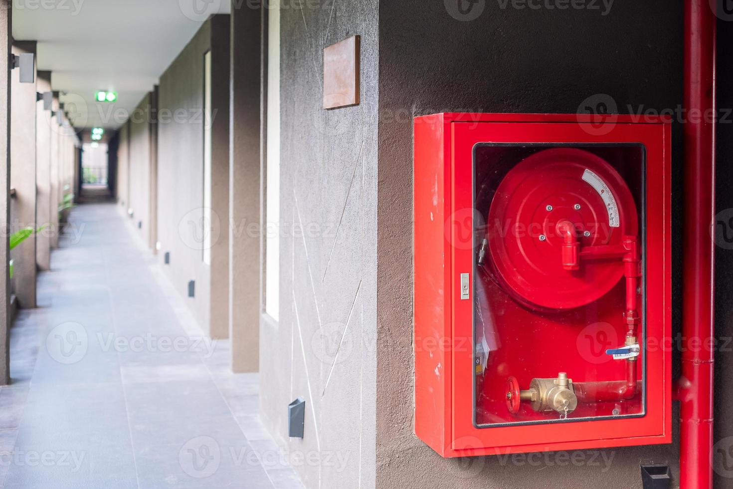 Fire extinguisher and water pump system on the wall background, powerful emergency equipment for industrial and residential photo