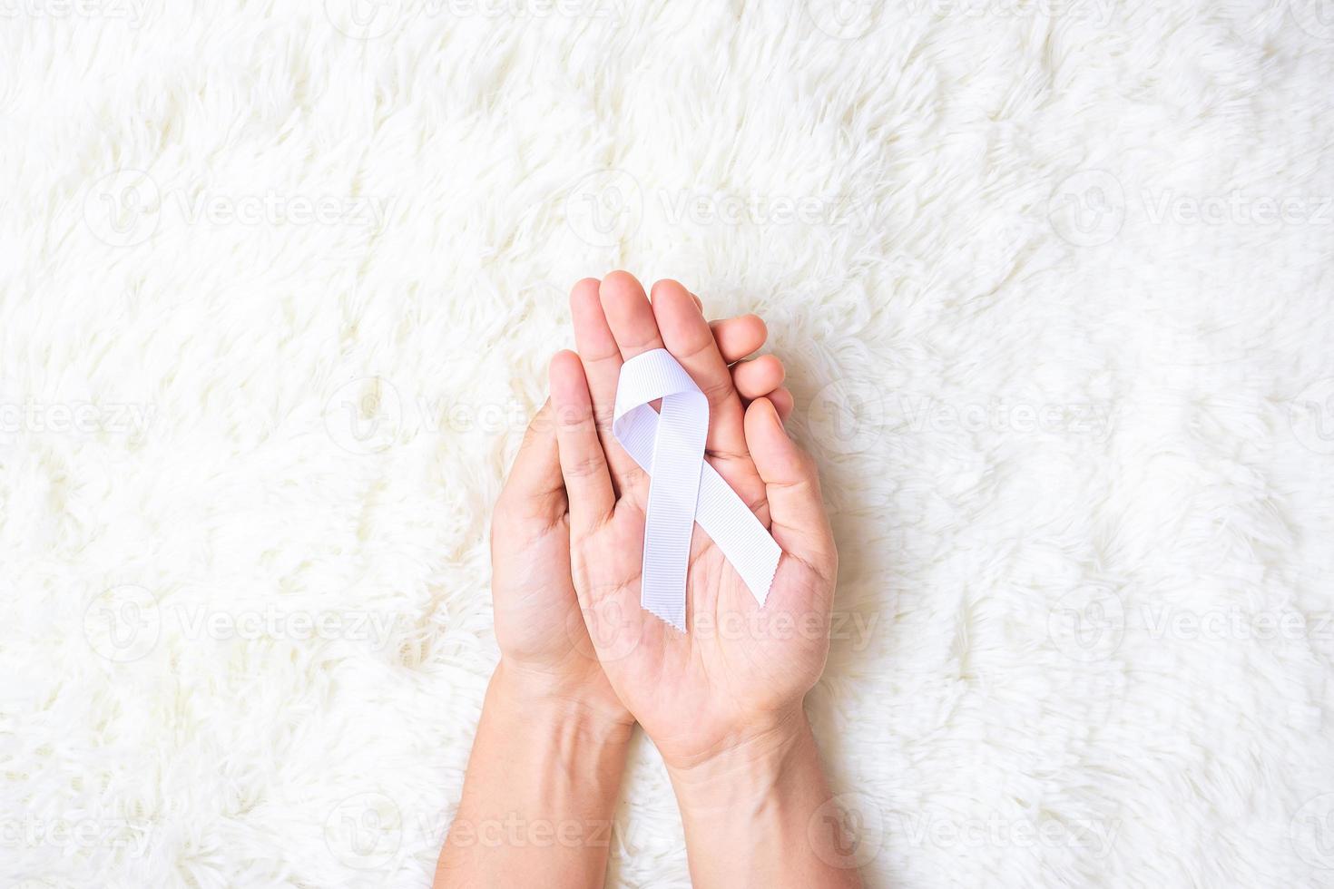 November Lung Cancer Awareness month, democracy and international peace day. Man holding white Ribbon on white background photo