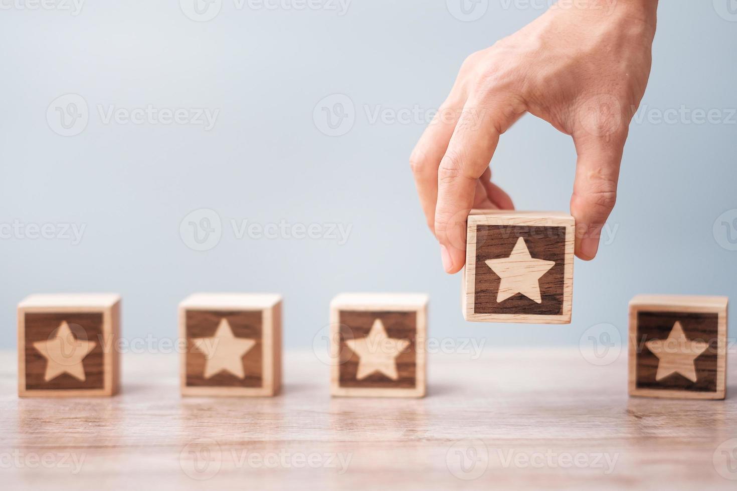 Man hand holding Star block. Customer choose rating for user reviews. Service rating, ranking, customer review, satisfaction, evaluation and feedback concept photo