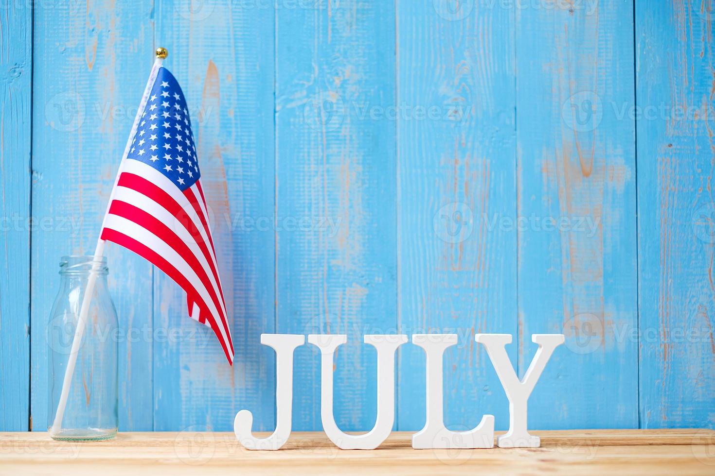 July text and United States of America flag on wooden table background. USA holiday of Independence and celebration concepts photo