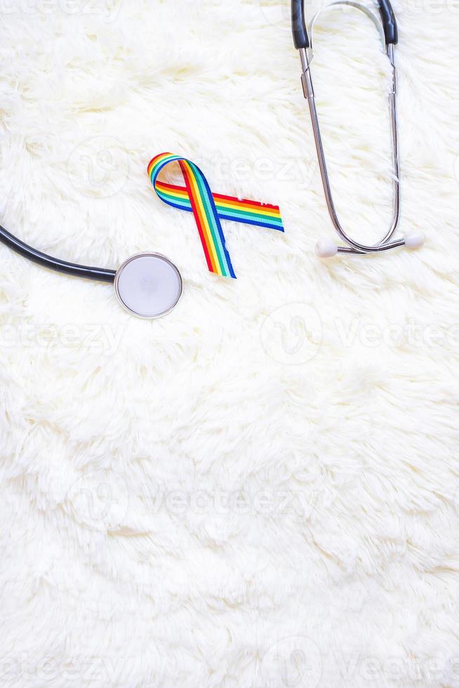 LGBTQ Rainbow ribbon with stethoscope on white background. Support Lesbian, Gay, Bisexual, Transgender, Queer community and Rights concept photo