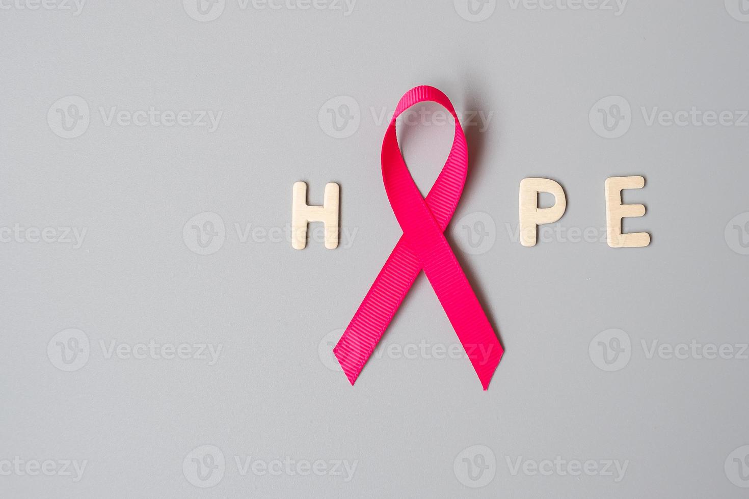 October Breast Cancer Awareness month, Pink Ribbon with HOPE text on grey background for supporting people living and illness. International Women, Mother and World cancer day concept photo