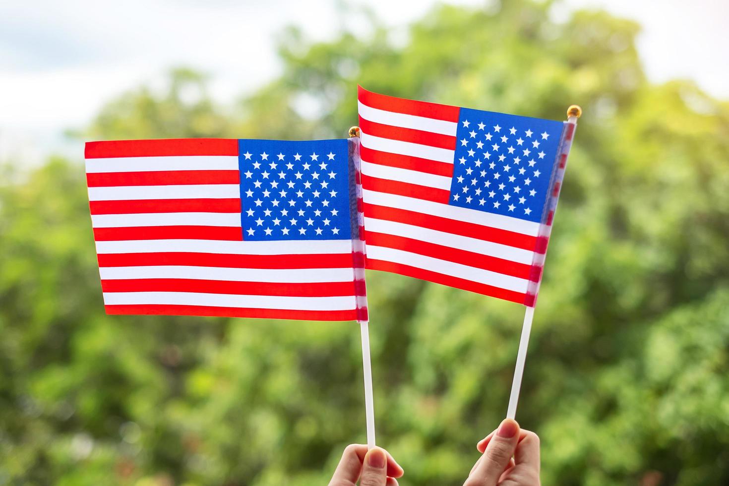 mano que sostiene la bandera de los Estados Unidos de América sobre fondo verde. fiesta de los veteranos en estados unidos, memorial, independencia y concepto del día del trabajo foto