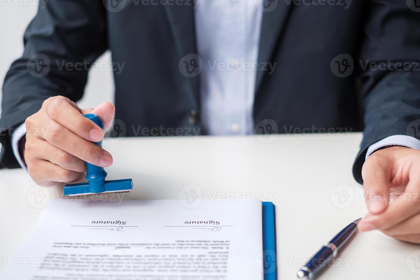 Businessman stamp during signing contract document.Business contract, approve, partnership, contract agreement and quality assurance concepts photo