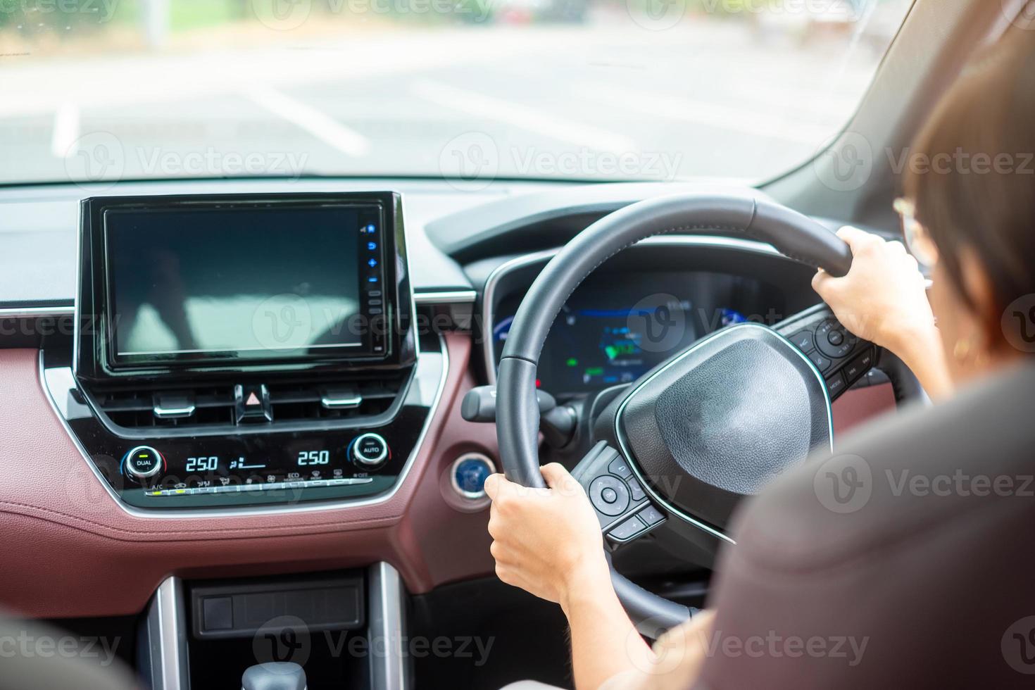 woman driver driving a car on the road, hand controlling steering wheel in electric modern automobile. Journey, trip and safety Transportation concepts photo