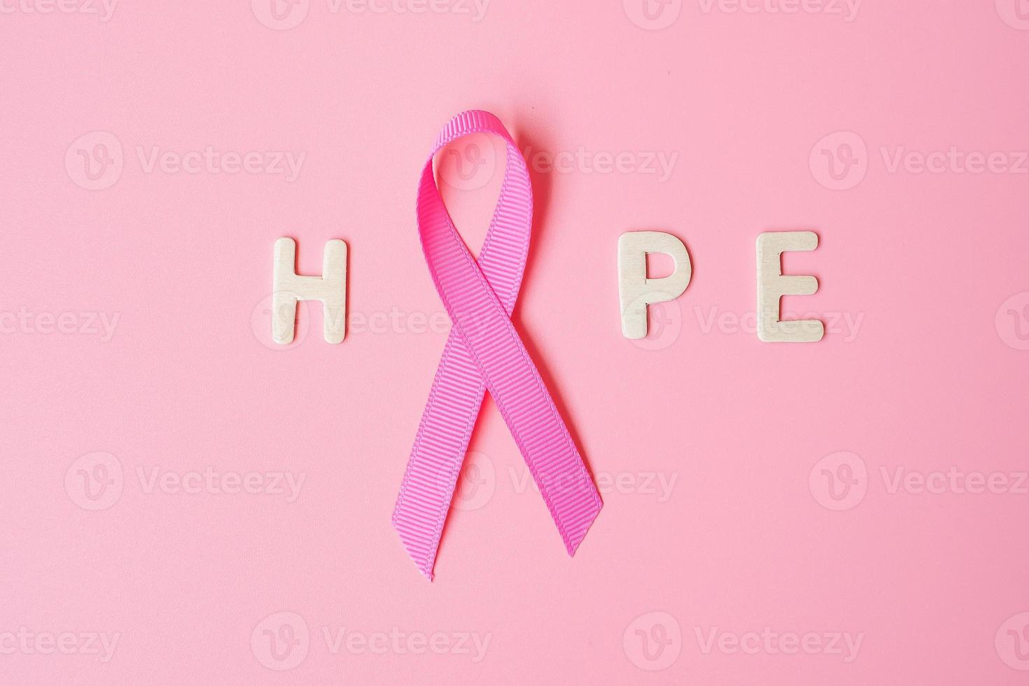 octubre mes de concientización sobre el cáncer de mama, cinta rosa con texto de esperanza sobre fondo rosa para apoyar a las personas que viven y están enfermas. concepto del día internacional de la mujer, la madre y el día mundial del cáncer foto