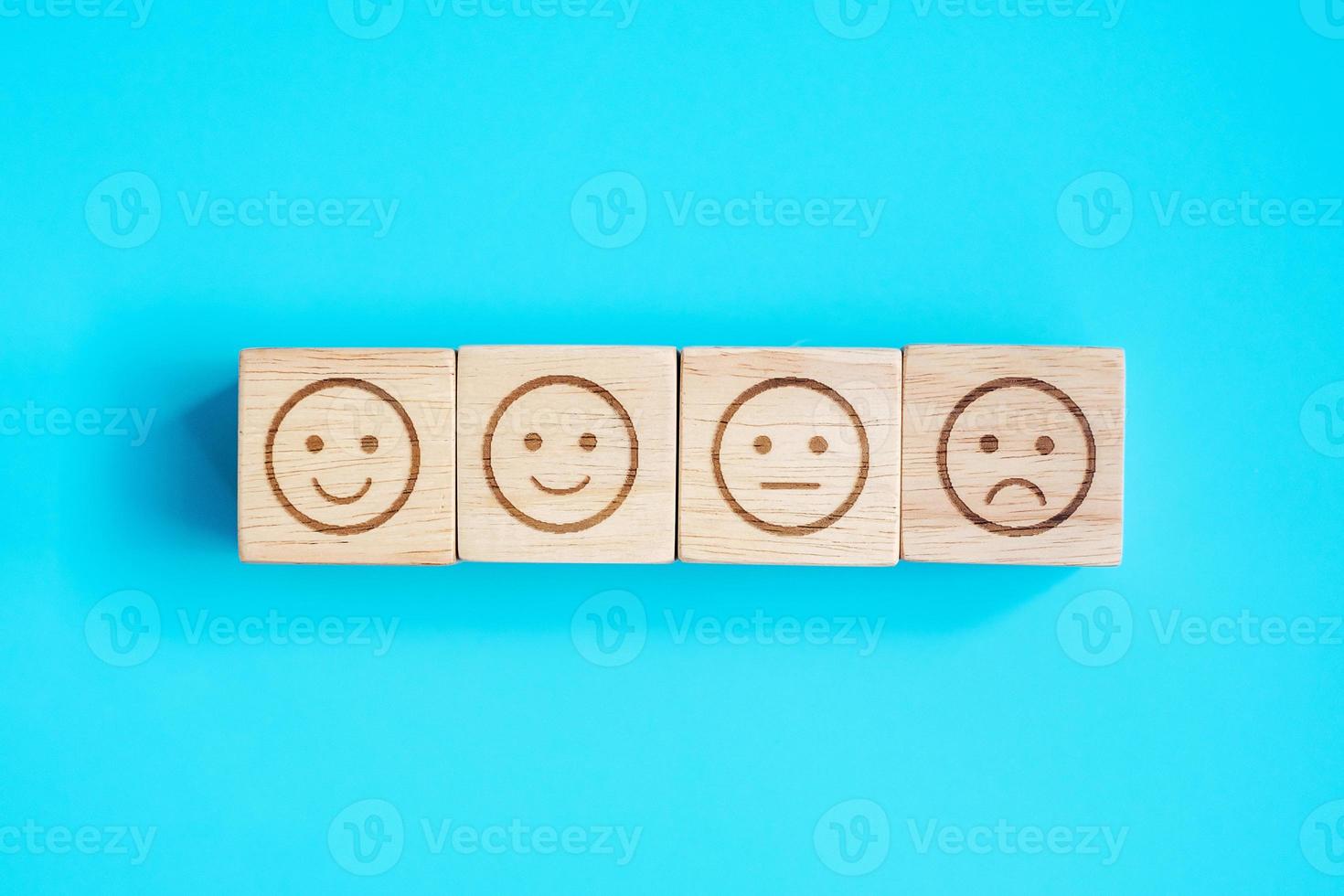 emotion face symbol blocks on blue background. Service rating, ranking, customer review, satisfaction, evaluation and feedback concept photo