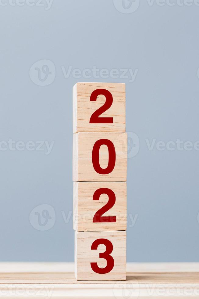 wooden cube block with 2023 text on table background. Resolution, plan, review, goal, start and New Year holiday concepts photo
