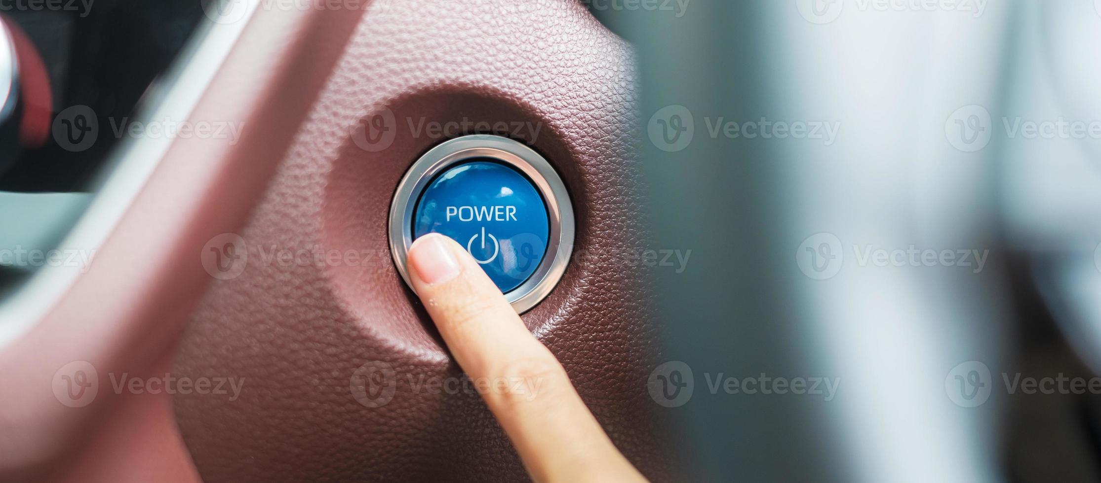 Finger press a car ignition button or START engine inside modern electric automobile. Keyless, change, strategy, vision, innovation and future concept photo