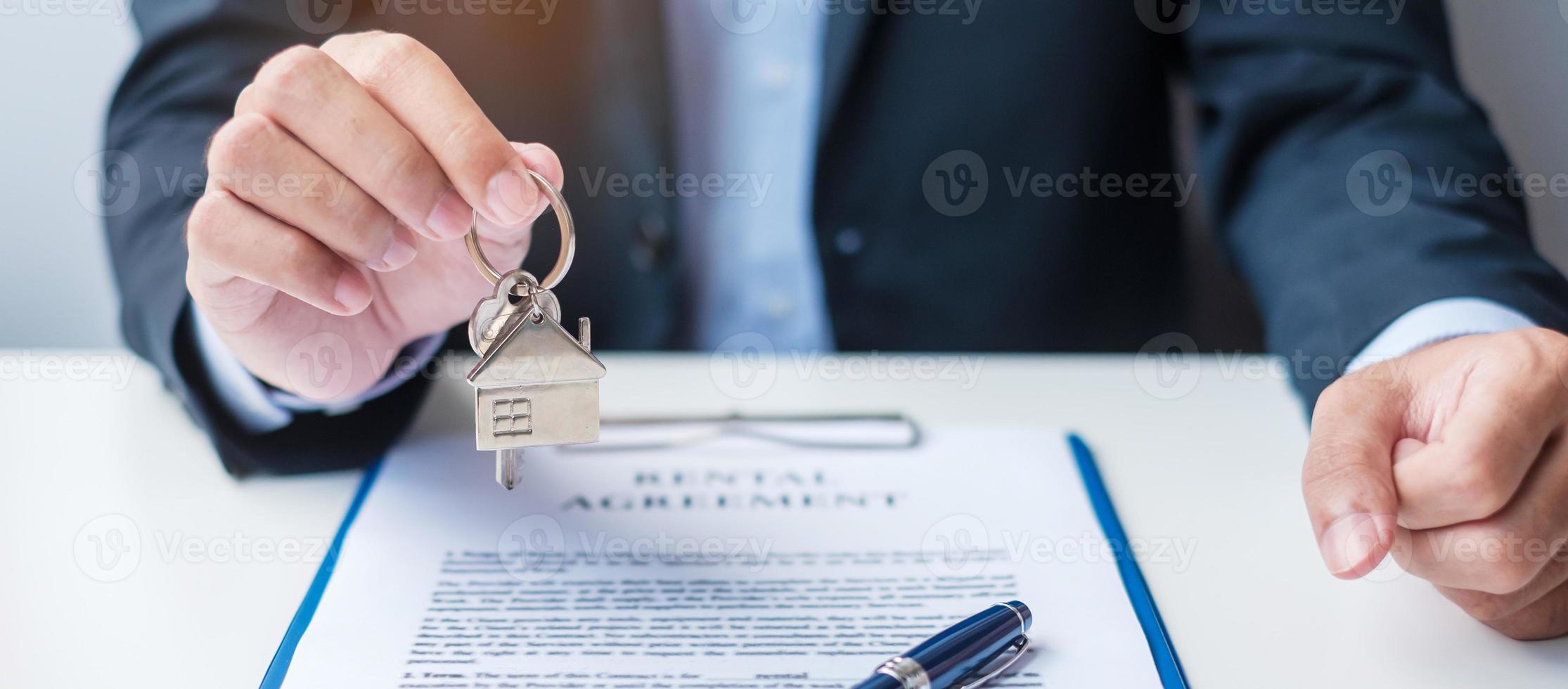 man holding home key during signing home contract documents. Contract agreement, real estate,  buy and sale and insurance concepts photo