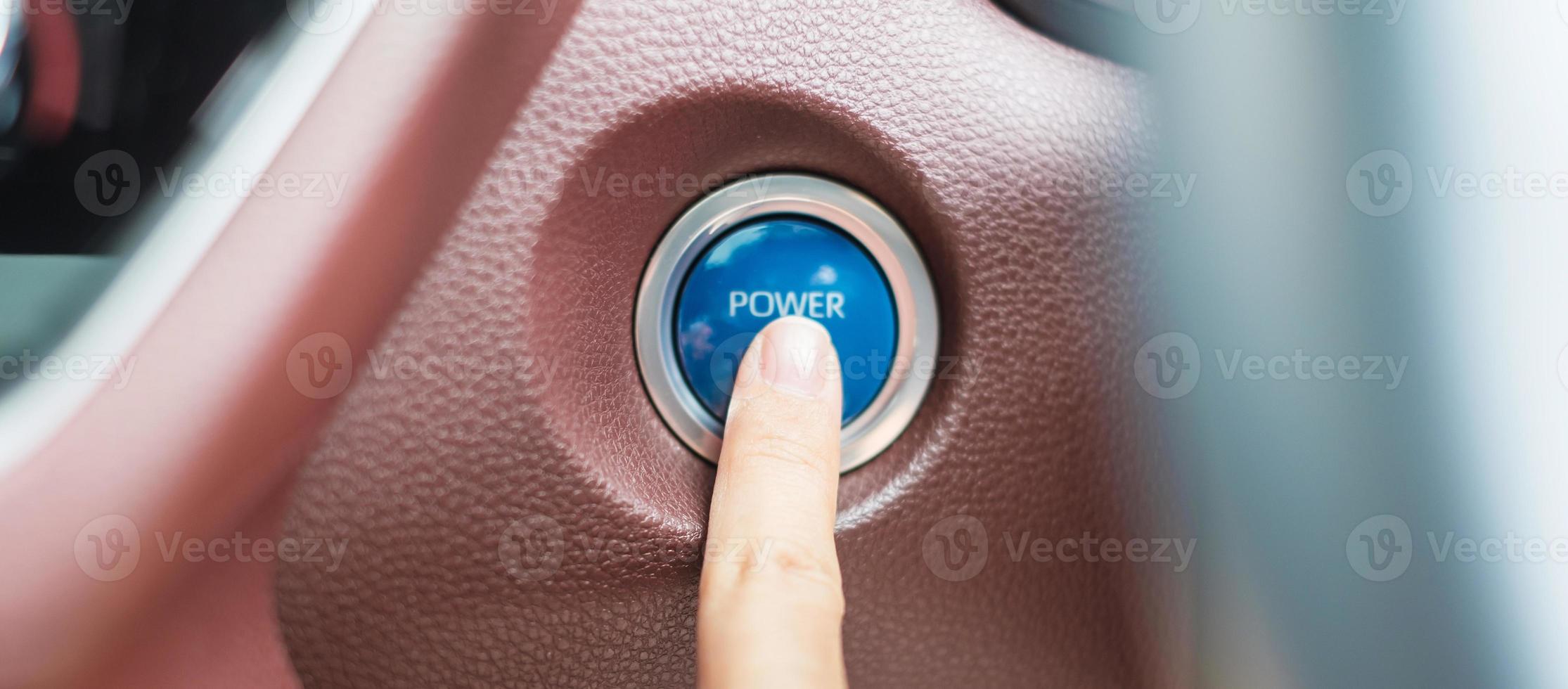 Finger press a car ignition button or START engine inside modern electric automobile. Keyless, change, strategy, vision, innovation and future concept photo