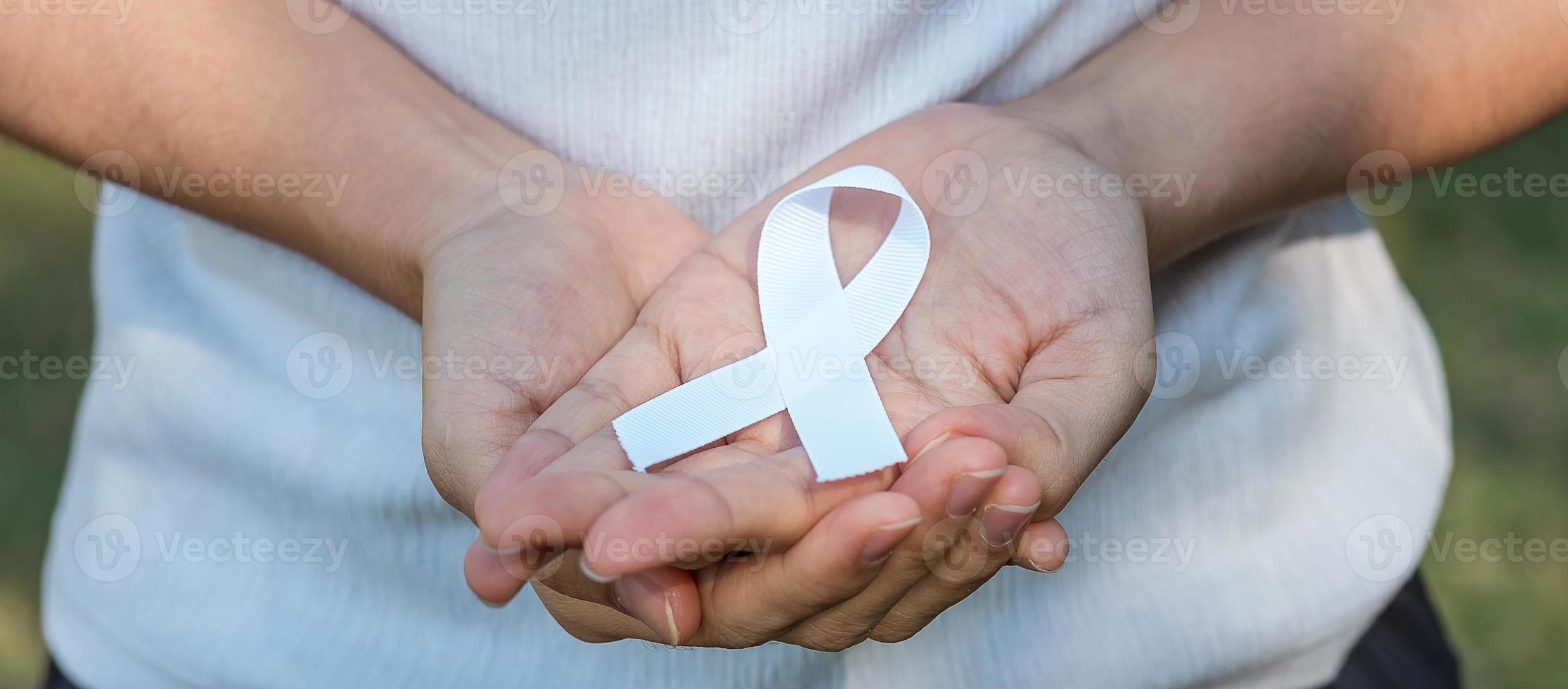 November Lung Cancer Awareness month, democracy and international peace day. Woman holding white Ribbon photo