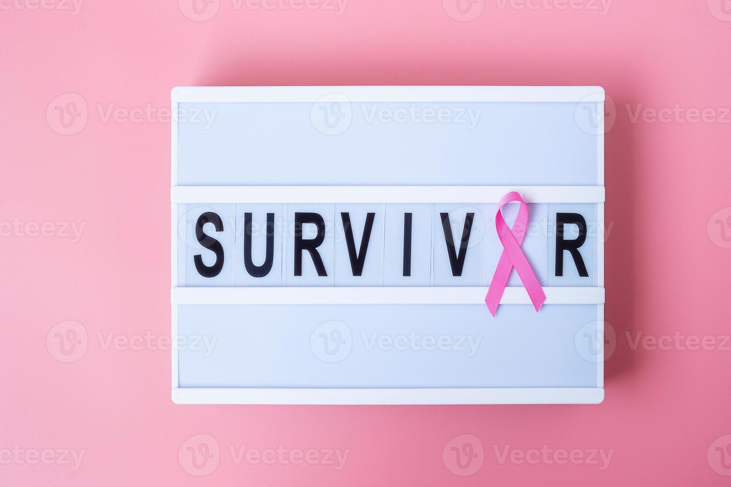 October Breast Cancer Awareness month, Pink Ribbon on lightbox with SURVIVOR text background for supporting people living and illness. International Women, Mother and World cancer day concept photo