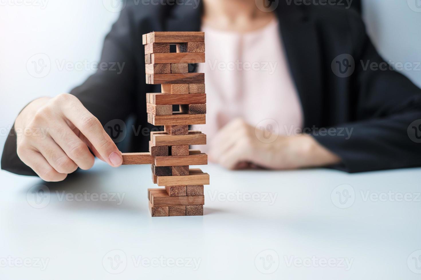 Businesswoman hand placing or pulling wooden block on the tower. Business planning, Risk Management, Solution and strategy Concepts photo