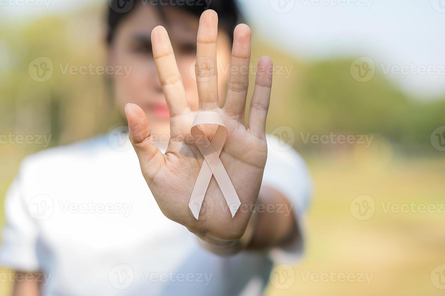 September Uterine Cancer Awareness month, woman hand holding Peach Ribbon for supporting people living and illness. Healthcare and World cancer day concept photo