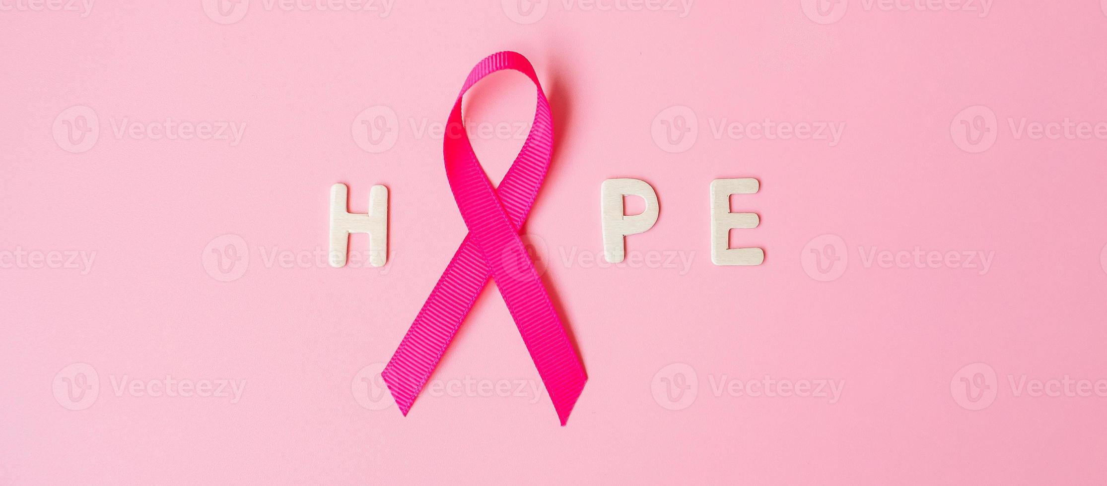 October Breast Cancer Awareness month, Pink Ribbon with HOPE text on pink background for supporting people living and illness. International Women, Mother and World cancer day concept photo