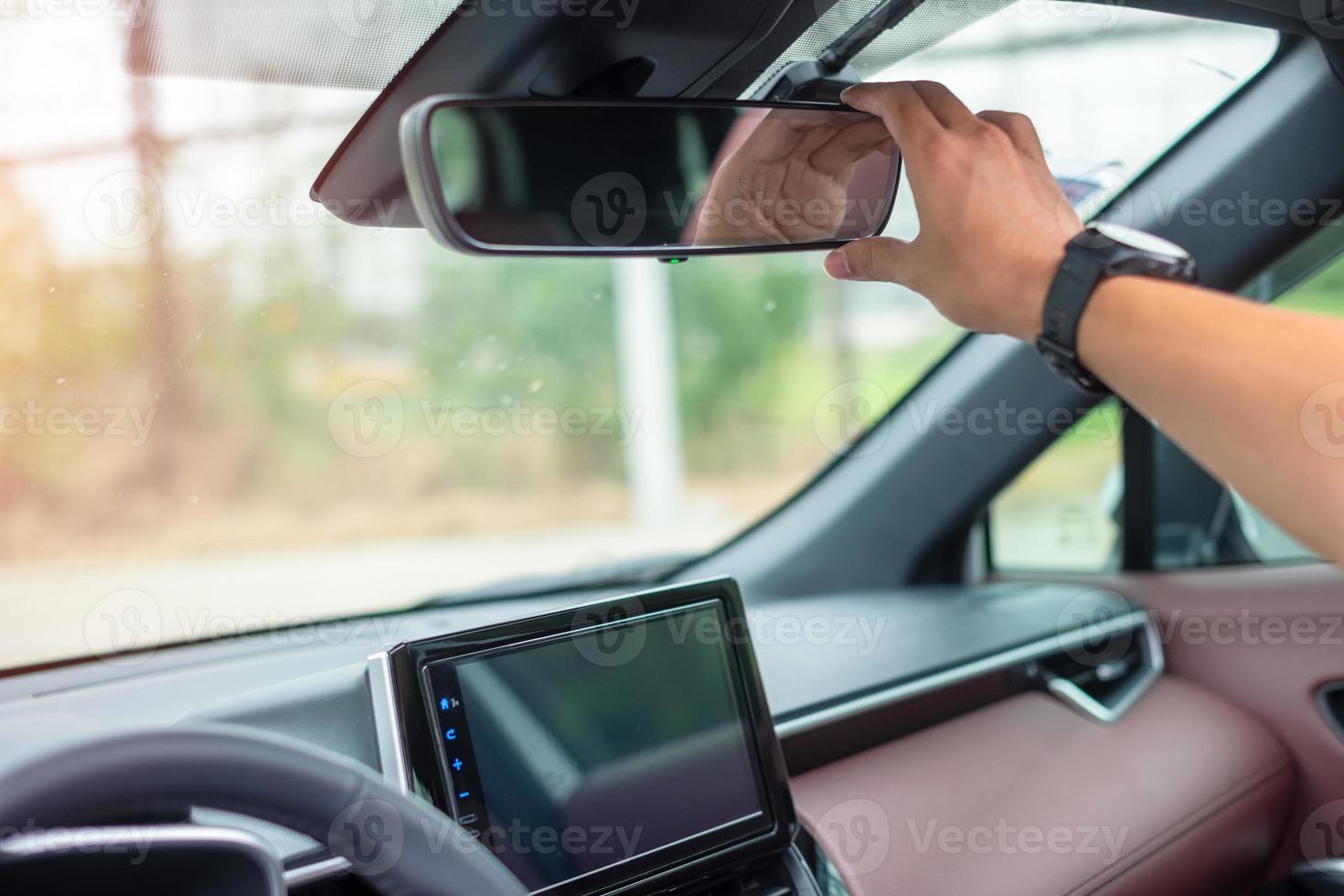 hombre conductor ajustando el espejo retrovisor de un coche. conceptos de transporte de viaje, viaje y seguridad foto