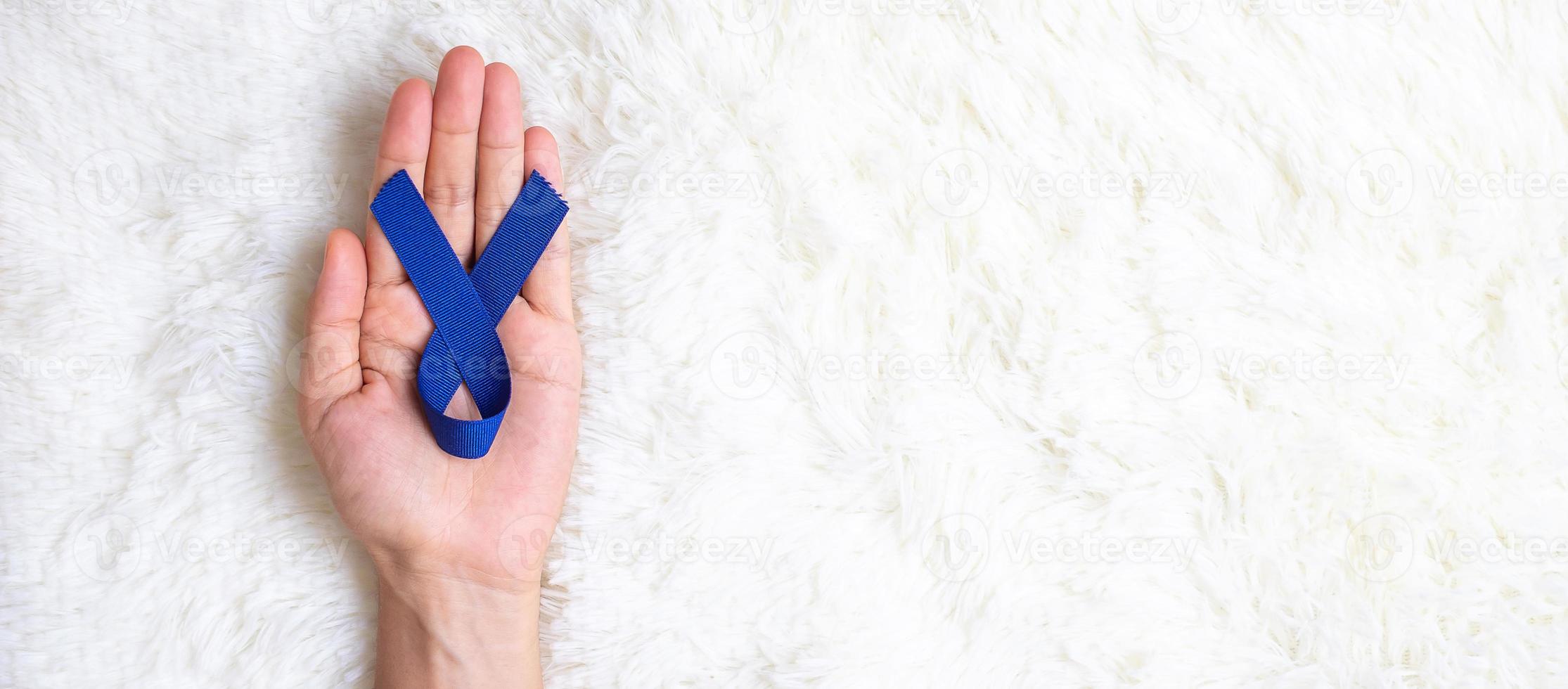marzo mes de concientización sobre el cáncer colorrectal, hombre con cinta azul oscuro para apoyar a las personas que viven y están enfermas. concepto de salud, esperanza y día mundial contra el cáncer foto