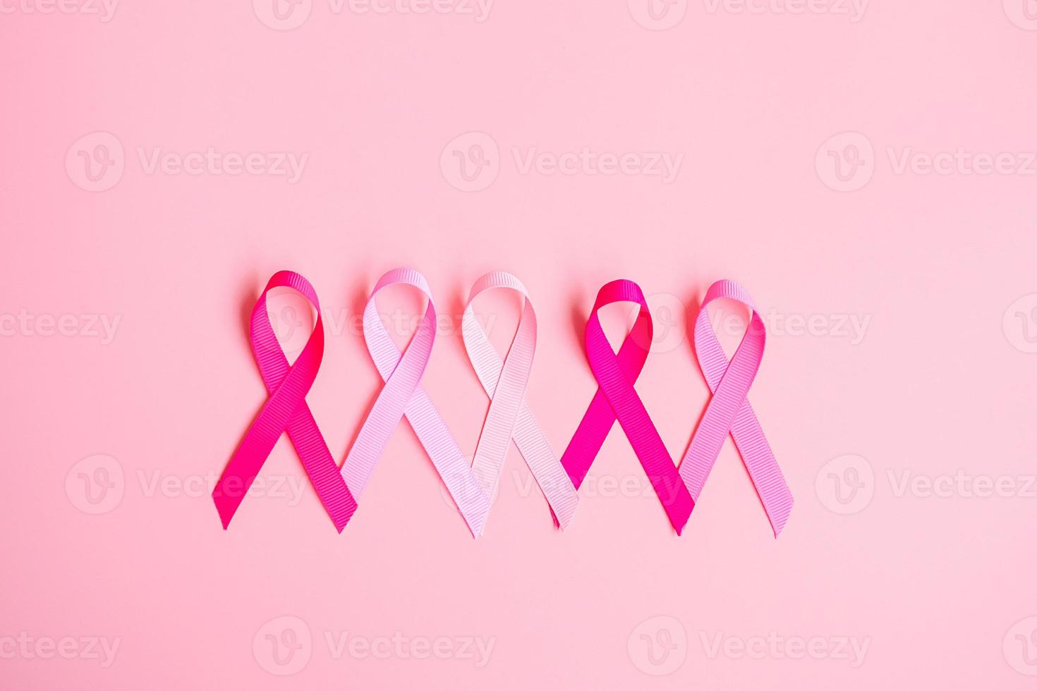 octubre mes de concientización sobre el cáncer de mama, cinta rosa sobre fondo rosa para apoyar a las personas que viven y están enfermas. concepto del día internacional de la mujer, la madre y el día mundial del cáncer foto