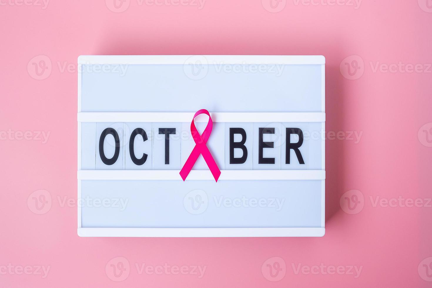 mes de concientización sobre el cáncer de mama, cinta rosa en la caja de luz con fondo de texto de octubre para apoyar a las personas que viven y están enfermas. concepto del día internacional de la mujer, la madre y el día mundial del cáncer foto