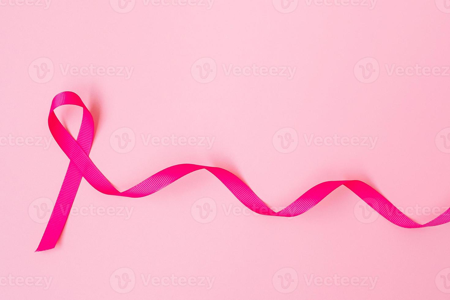 octubre mes de concientización sobre el cáncer de mama, cinta rosa sobre fondo rosa para apoyar a las personas que viven y están enfermas. concepto del día internacional de la mujer, la madre y el día mundial del cáncer foto