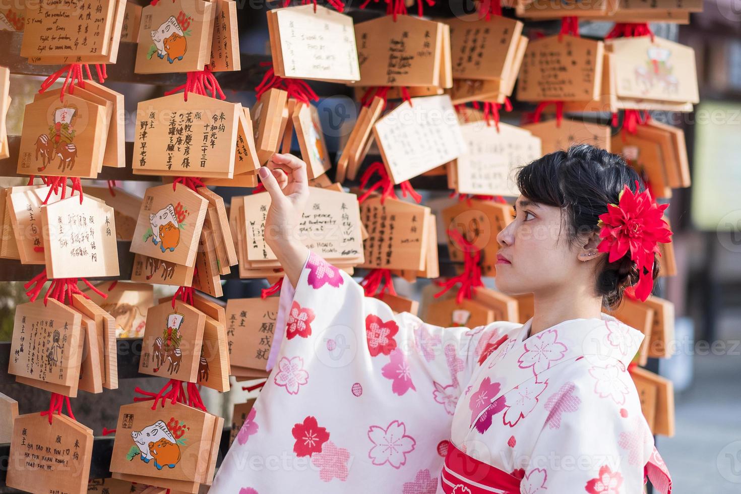 joven turista vistiendo kimono en el templo kiyomizu dera, kyoto, japón. chica asiática con estilo de cabello en ropa tradicional japonesa en la temporada de follaje de otoño foto