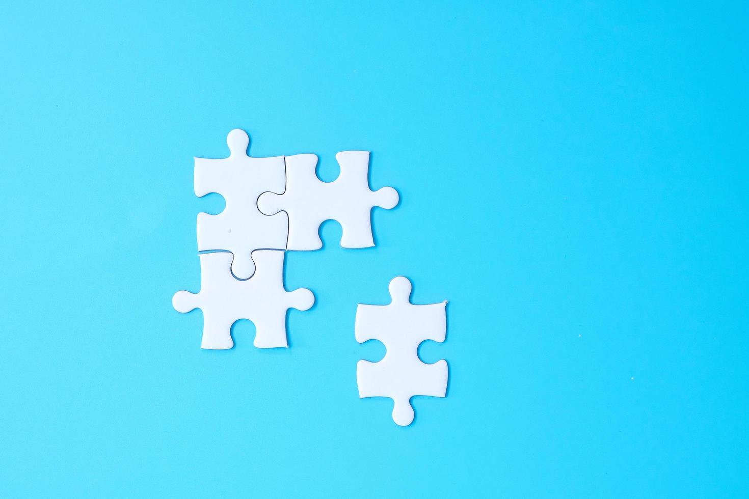 Group of white puzzle jigsaw pieces on blue background. Concept of solutions, mission, success, goals, cooperation, partnership, strategy and puzzle day photo